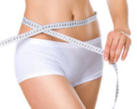 Picture of a woman holding a measure tape to her hips after liposculpture